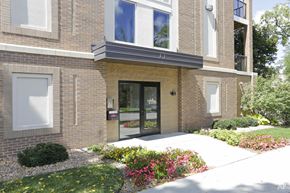 Rochester apartment for rent - a sidewalk in front of a brick building with glass doors