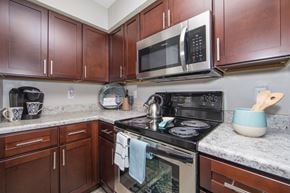 Virginia Beach apartment for rent - Kitchen with granite countertops stainless microwave and electric stove at St. Croix Apartments in Virginia Beach VA