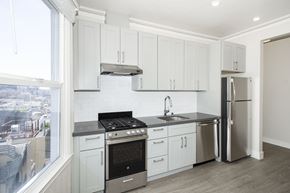 San Francisco apartment for rent - A kitchen with white cabinets and a stainless steel refrigerator.