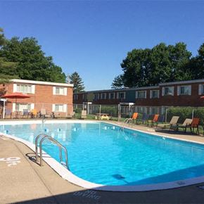 Brookpark apartment for rent - a large swimming pool in front of brick apartment buildings