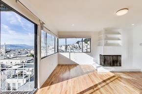 San Francisco apartment for rent - A modern room with a fireplace and a view of the city.