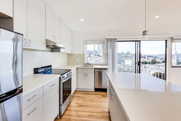 San Francisco apartment for rent - A modern kitchen with white cabinets and stainless steel appliances.