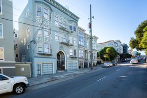 San Francisco apartment for rent - A street view of a residential area with a white car parked on the side of the road.
