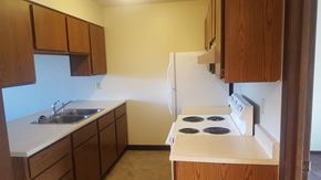 Kalispell apartment for rent - Image showing sink, cabinets refrigerator, and stove with range hood