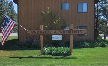 Post Falls apartment for rent - a sign for parkside apartments in front of a building