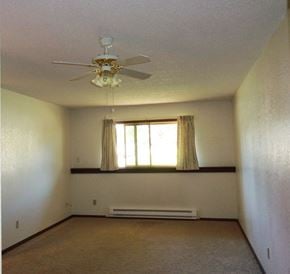 Libby apartment for rent - Image of bedroom with overhead fan, base board heater, and window