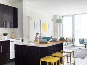 Allston apartment for rent - a kitchen with yellow bar stools and a table with yellow chairs