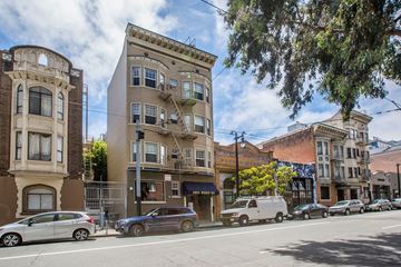 San Francisco apartment for rent - A street view of a row of buildings with cars parked on the side of the road.