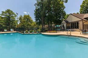 Madison apartment for rent - A large swimming pool surrounded by trees and a building.