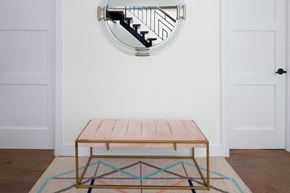 Brooklyn apartment for rent - A wooden table with a metal frame and a rug with a geometric pattern in front of it.