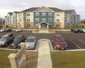 Worthington apartment for rent - a parking lot with cars in front of an apartment building
