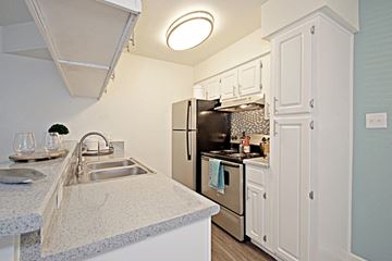 Mesa apartment for rent - a kitchen with white cabinets and a sink and a refrigerator