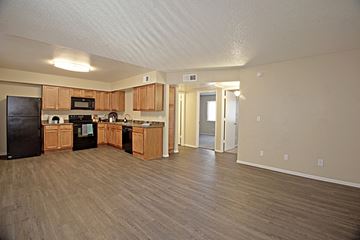 Phoenix apartment for rent - an open kitchen and living room with wooden floors and wood cabinets