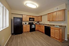 Phoenix apartment for rent - a kitchen with wooden cabinets and a black refrigerator