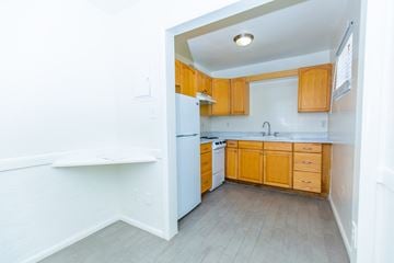 Phoenix apartment for rent - an empty kitchen with wooden cabinets and a white refrigerator