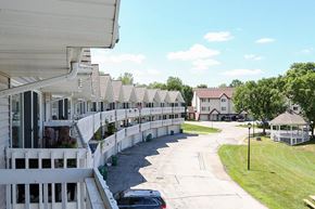 Hartland apartment for rent - A white fence runs along the side of a building.