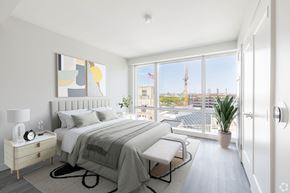 Boston apartment for rent - A bedroom with a large bed and a view of the city.