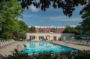 Albany apartment for rent - a swimming pool with chairs and a building in the background