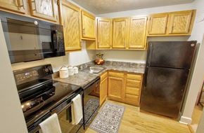 Albany apartment for rent - a kitchen with stainless steel appliances and wooden cabinets