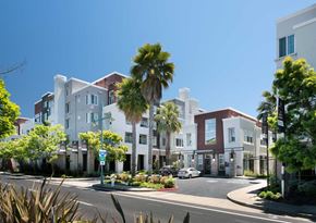 Emeryville apartment for rent - a row of apartment buildings with palm trees in front of them