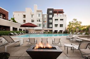 Emeryville apartment for rent - a pool with chairs and a fire pit in front of a hotel pool