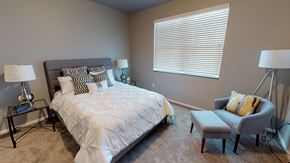 Mandan townhouse for rent - a bedroom with a bed and a chair and a window