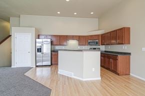 Minot townhouse for rent - an empty kitchen with an island and stainless steel appliances