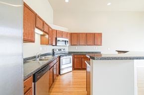 Minot townhouse for rent - an empty kitchen with wooden cabinets and granite counter tops