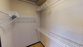 Minot townhouse for rent - a spacious closet with two shelves and two racks on the wall