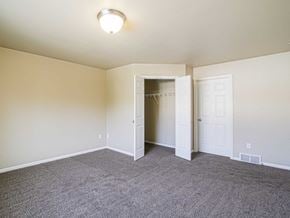 Minot townhouse for rent - an empty living room with carpet and a closet