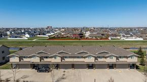 Fargo townhouse for rent - A large building with a parking lot in front of it.