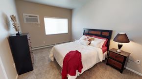 Moorhead apartment for rent - bedroom with red and white bedding