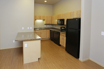 Moorhead apartment for rent - a kitchen with black appliances and a granite counter top
