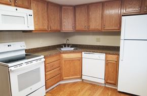 Orchard Park apartment for rent - A kitchen with wooden cabinets and white appliances.