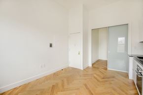 Brooklyn apartment for rent - A room with a wooden floor and white walls.