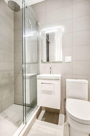 Brooklyn apartment for rent - A white toilet sits next to a sink in a modern bathroom.