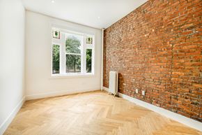 Brooklyn apartment for rent - A room with a window and a brick wall.