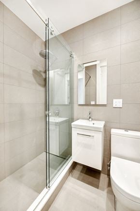 Brooklyn apartment for rent - A white bathroom with a glass shower stall.