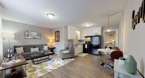 Greenville apartment for rent - A living room with a grey couch, a coffee table, and a television.