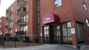 Toronto apartment for rent - a red brick apartment building with a red sign on the front of it