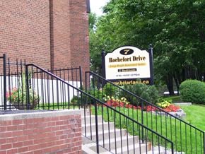 North York apartment for rent - A sign for Rochefort Drive is displayed in front of a brick building.