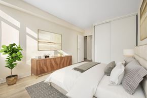 Toronto apartment for rent - A bedroom with a large bed and a wooden dresser.