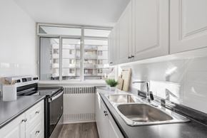 Etobicoke apartment for rent - A modern kitchen with a stainless steel sink and white cabinets.