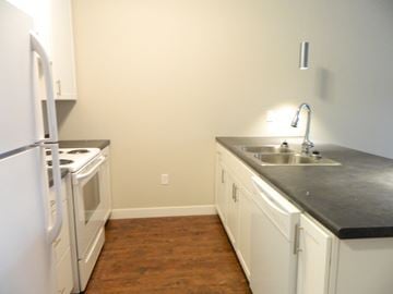 Burlington apartment for rent - a kitchen with white cabinets and a sink and a refrigerator