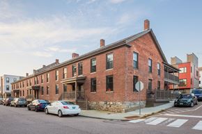 Winooski apartment for rent - a red brick apartment building on a city street with parked cars
