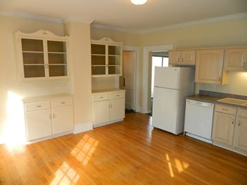 Winooski apartment for rent - an empty kitchen with white cabinets and a refrigerator