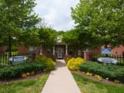 Dundalk apartment for rent - the front of a brick building with a sidewalk and a garden