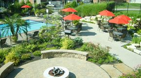 St. Louis apartment for rent - a patio with tables and umbrellas near a swimming pool