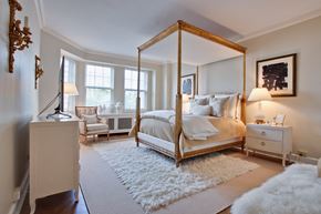 Chicago apartment for rent - A bedroom with a four poster bed and a white rug.