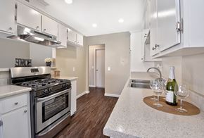 Orange apartment for rent - a kitchen with stainless steel appliances and white cabinets